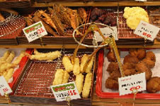 浦添市スーパー内の天ぷらコーナー。スティック状の魚の天ぷらやサーターアンダギーが並ぶ。