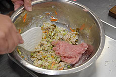 潰したご飯に高菜漬けもの・枝豆・ゴマ・人参を加えて混ぜ合わせ、ご飯とほぼ同量のワニ肉を加えます。