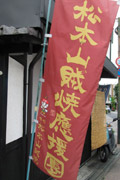 「松本山賊焼応援団」の加盟店に掲げられているのぼり旗。